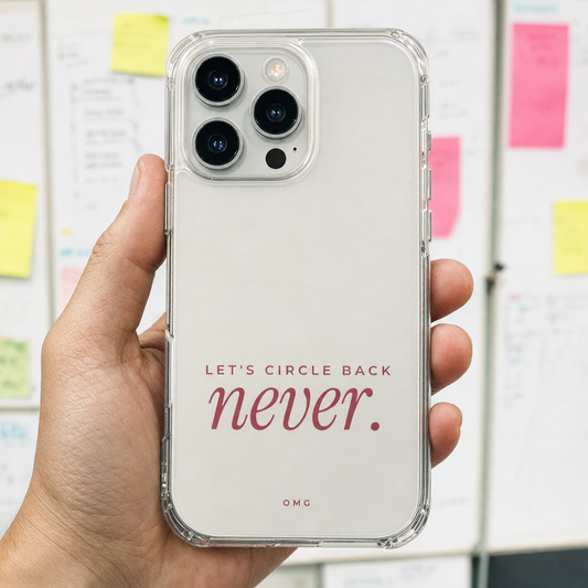 Clear iPhone case printed “Let’s circle back. never.” in dark rose, held by an office whiteboard