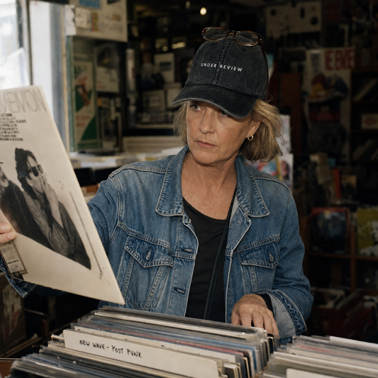 Under Review embroidered vintage cap in black, worn in a record shop